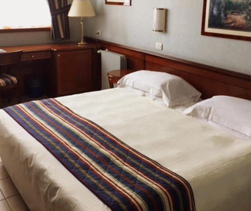 a bedroom with a large bed with two pillows at Ripamonti Residence & Hotel Milano in Pieve Emanuele
