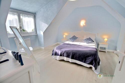 Le ploubaz في بلوبازلانيك: غرفة نوم مع سرير مع لحاف أرجواني