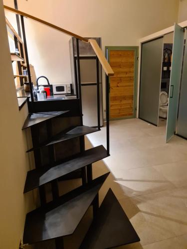 Una escalera de caracol en una cocina con puerta en Desert view studio, en Beʼer Ora
