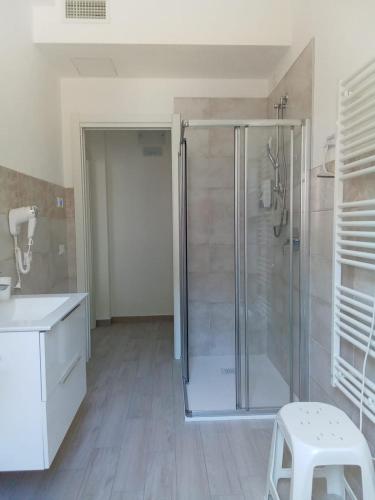 een badkamer met een douche en een witte kruk bij Appartamenti Milietta 1 in Monzambano