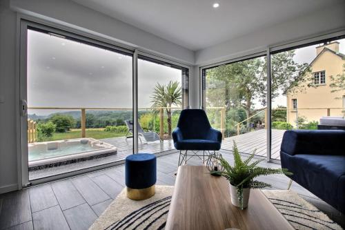 - un salon avec vue sur une grande fenêtre en verre dans l'établissement Breizh carpe diem, à Gicquel