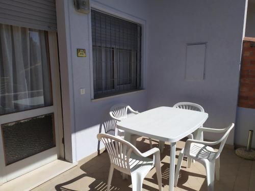 - Balcón con mesa blanca y 4 sillas en Bright villa with private garden - Beahost Rentals, en Caorle