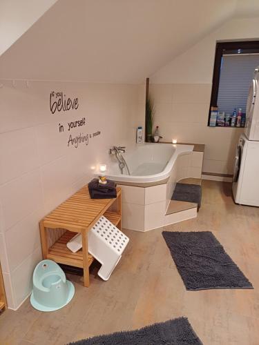 La salle de bains est pourvue d'une baignoire, d'une table et d'un lavabo. dans l'établissement Das Tor zur Rhön, 