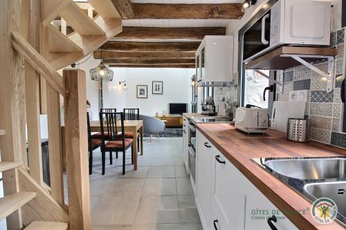 une cuisine avec des placards blancs et une salle à manger dans l'établissement Le littoral, à Gicquel