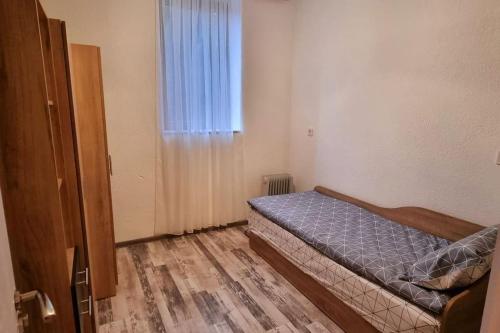 Habitación pequeña con cama y ventana en Sweet Home Apartament, en Smolyan