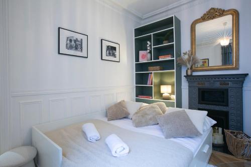Cama blanca en habitación con espejo en Lovely Apartment next to Roland Garros - V90 en París