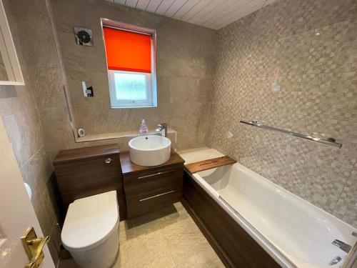 y baño con aseo, lavabo y bañera. en 2 Bedroom Apartment near Glasgow Airport, en Renfrew