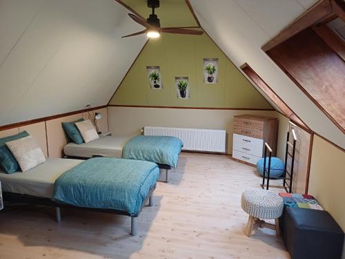 VoorstにあるBed & Breakfast Appensewegの天井の屋根裏部屋で、ベッド2台が備わります。