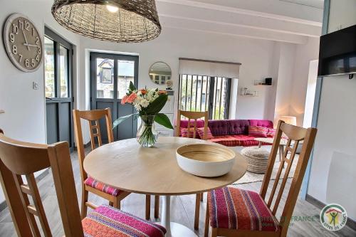 une salle à manger avec une table avec un vase de fleurs dans l'établissement La lagune, à Gicquel