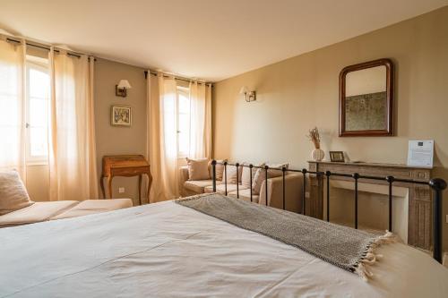 a bedroom with a bed and a mirror on the wall at Château MontPlaisir charming b&b in Provence in Valréas
