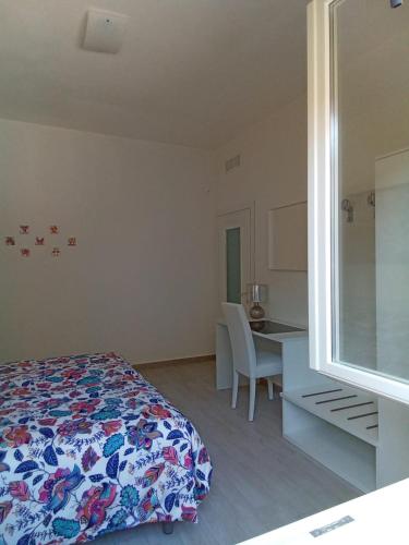 een slaapkamer met een bed, een tafel en een bureau bij Appartamenti Milietta 1 in Monzambano