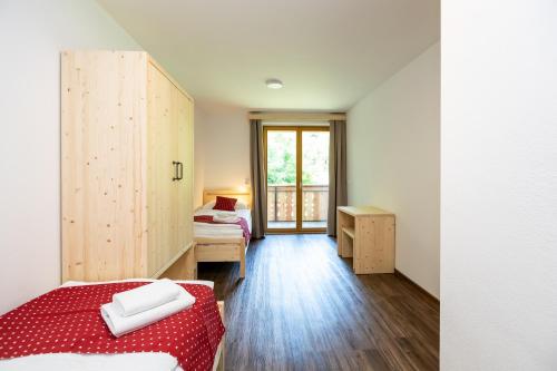 a small room with two beds and a window at Bohinj Apartments Goldhorn Kingdom in Bohinj