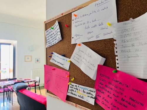 a bulletin board with notes on a wall at Regina d’Aragona casa vacanze in Sulmona