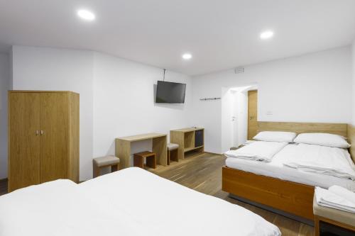 a bedroom with two beds and a tv on the wall at B&B Pri Peclju in Podgrad