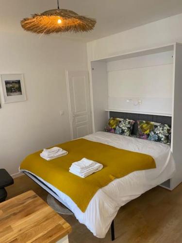 une chambre avec un lit avec une couverture jaune dessus dans l'établissement Cozy modern studio, à Paris