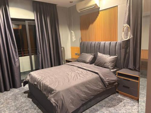 a bedroom with a bed with a gray headboard at Skyloft Suite in Lagos