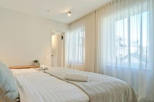 sypialnia z dużym łóżkiem i dużym oknem w obiekcie Modernes Flair: Designer-Apartment in Top-Lage! w mieście Wittlich