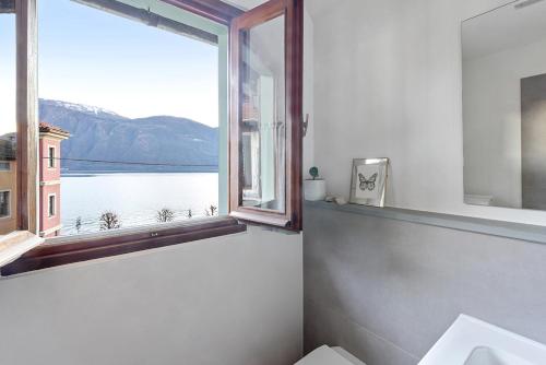 a bathroom with a window with a view of the water at Casa Rina in Cannobio