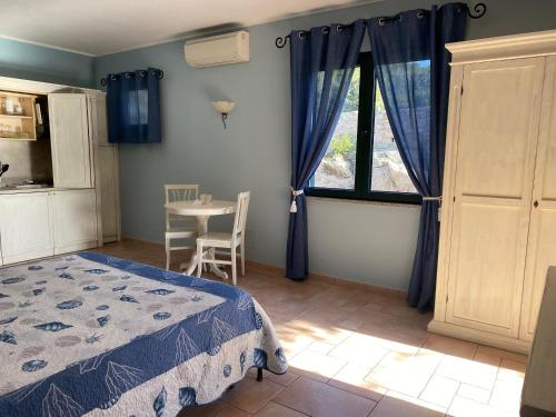 sypialnia z łóżkiem, stołem i oknem w obiekcie Hotel Villa Del Parco w mieście La Maddalena