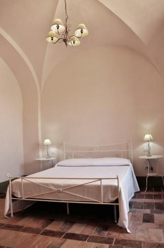 a bedroom with a white bed with two tables at B&B Antica Biblioteca in Fermo