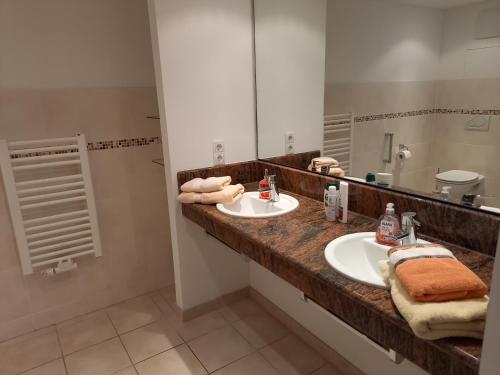 uma casa de banho com 2 lavatórios e um espelho grande em Wellness Ferienwohnung mit Bademantelgang zur Therme em Bad Griesbach