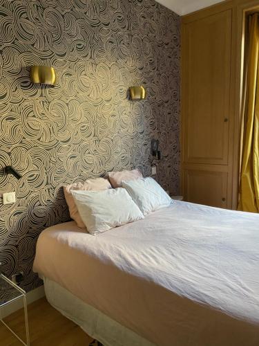 un lit avec deux oreillers dessus dans une chambre dans l'établissement Paris, grand appartement familial, porte Maillot, à Neuilly-sur-Seine