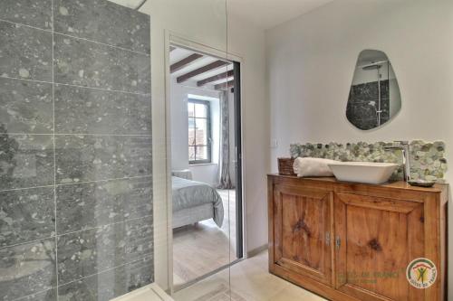 ein Bad mit einer Dusche, einem Waschbecken und einem Spiegel in der Unterkunft La motte in Plourhan