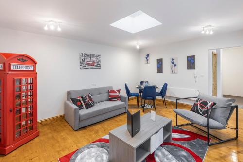 a living room with a couch and a red phone booth at Iconic London Apartment in London