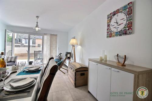 une salle à manger avec une table et une horloge au mur dans l'établissement O pesked d'harbour, à Saint-Quay-Portrieux