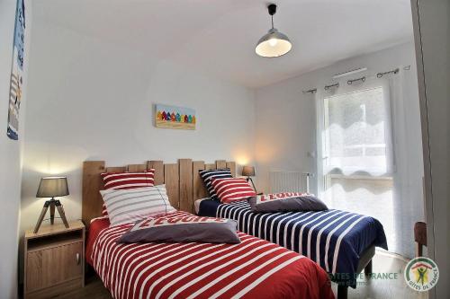 um quarto com 2 camas com lençóis listrados em O pesked d'harbour em Saint-Quay-Portrieux