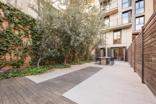 a courtyard with trees and a table and chairs at Sweett - Carrer Girona in Barcelona