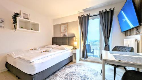Schlafzimmer mit einem Bett, einem Schreibtisch und einem Fenster in der Unterkunft ANDRISS - Study & Work Apartments - WIFI - Kitchen in Kaiserslautern