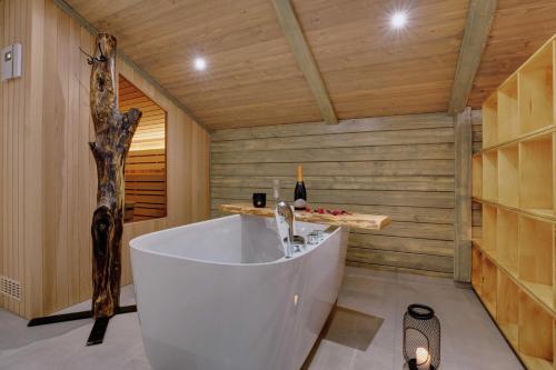 Habitación con paredes de madera y baño con bañera grande. en Apartment Hanny en Laško