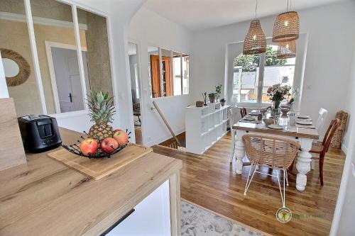 - une cuisine et une salle à manger avec une table et un bol de fruits dans l'établissement Ker-nath, à Saint-Quay-Portrieux