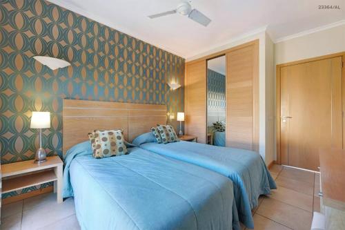 um quarto com uma cama azul num quarto em Pestana Carvoeiro Golfe - AL em Carvoeiro