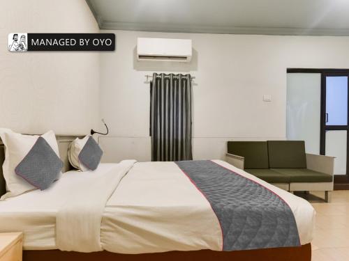 1 dormitorio con 1 cama grande y 1 silla en OYO Arpora Baga, en Baga