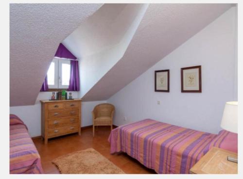 a bedroom with a bed and a dresser and a window at Somo Calle Ria Cubas in Somo