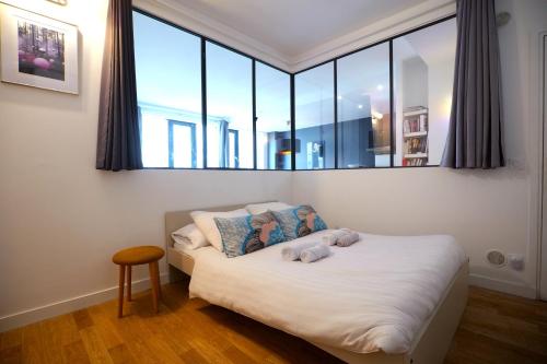 une chambre avec un lit avec un ours en peluche dessus dans l'établissement Beautiful parisian loft style in the heart of Paris, à Paris