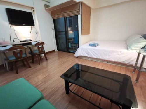 a room with a bed and a table and a desk at Cozy 1br walk to BTS and Airport Rail Link Close to Malls T in Bangkok