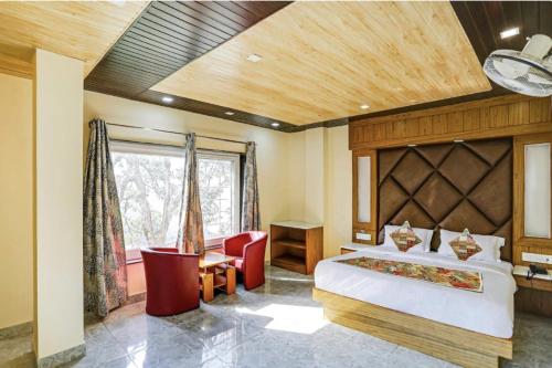 a bedroom with a bed and a desk and a window at Hotel Woods View - Mall Road in Mussoorie