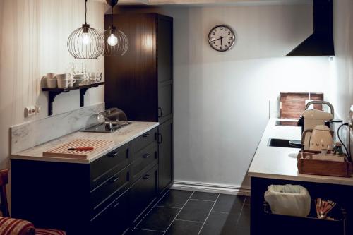 a kitchen with a sink and a clock on the wall at Villa Eckhoff in Stavanger