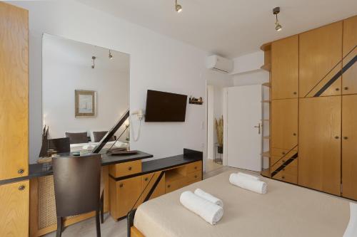 a room with a bed and a desk with a computer at Camelot Royal Beds by Estia in Malia