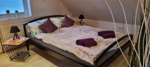 una camera da letto con letto e cuscini viola di Ferienwohnung Möwennest a Wangerland