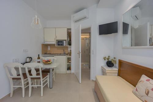 a kitchen and living room with a table and chairs at Camelot Royal Beds by Estia in Malia