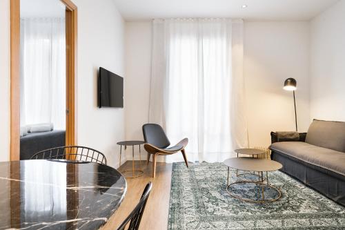 a living room with a glass table and a couch at Vale Suites in Barcelona