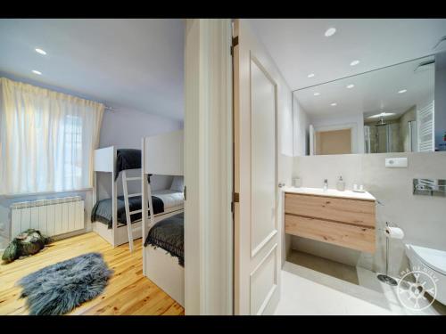 a bedroom with a bed and a sink and a mirror at HONT de Alma de Nieve in Gessa