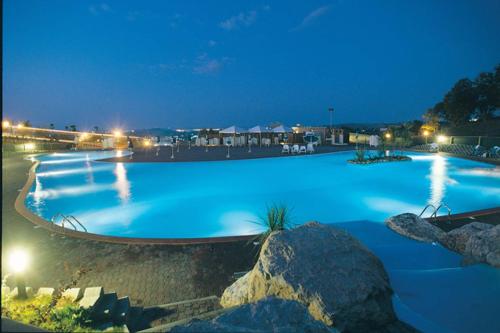 una gran piscina iluminada por la noche en Centro Vacanze San Marino en San Marino