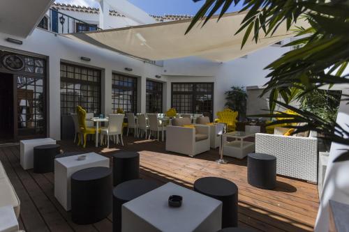 a restaurant with tables and chairs on a wooden deck at Josefa D`Obidos Hotel in Óbidos
