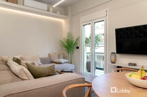 sala de estar con sofá y mesa en Muse Apartment by LobbySquare, en Atenas