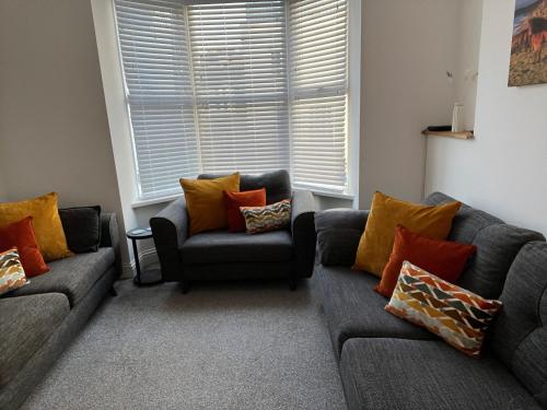 a living room with two couches and a chair at Saltwater Pearl - A charming 4 bed townhouse in Ilfracombe